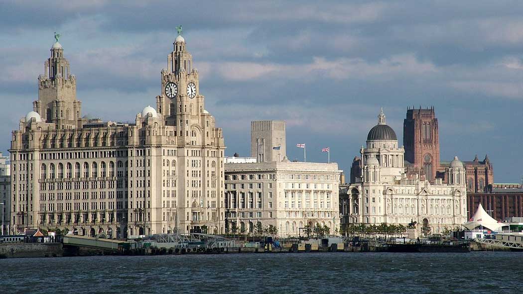 Liverpool Pier Head with (left to right) the Royal Liver Building, Cunard Building, the Port of Liverpool Building, which are sometimes referred to as the 'Three Graces' of Liverpool’s Pier Head. Liverpool's Anglican cathedral is in the background. (Photo: Chowells [CC BY-SA 3.0])