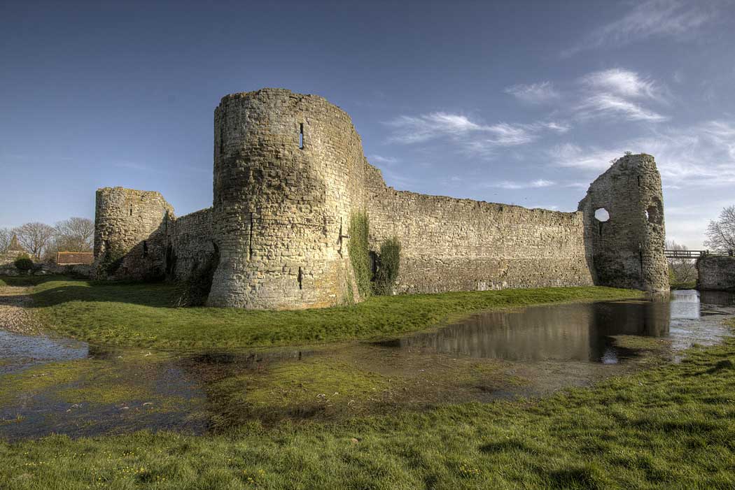 The curtain wall and the moat of the inner bailey at Pevensey Castle in Pevensey, East Sussex. (Photo: Prioryman [CC BY 3.0])