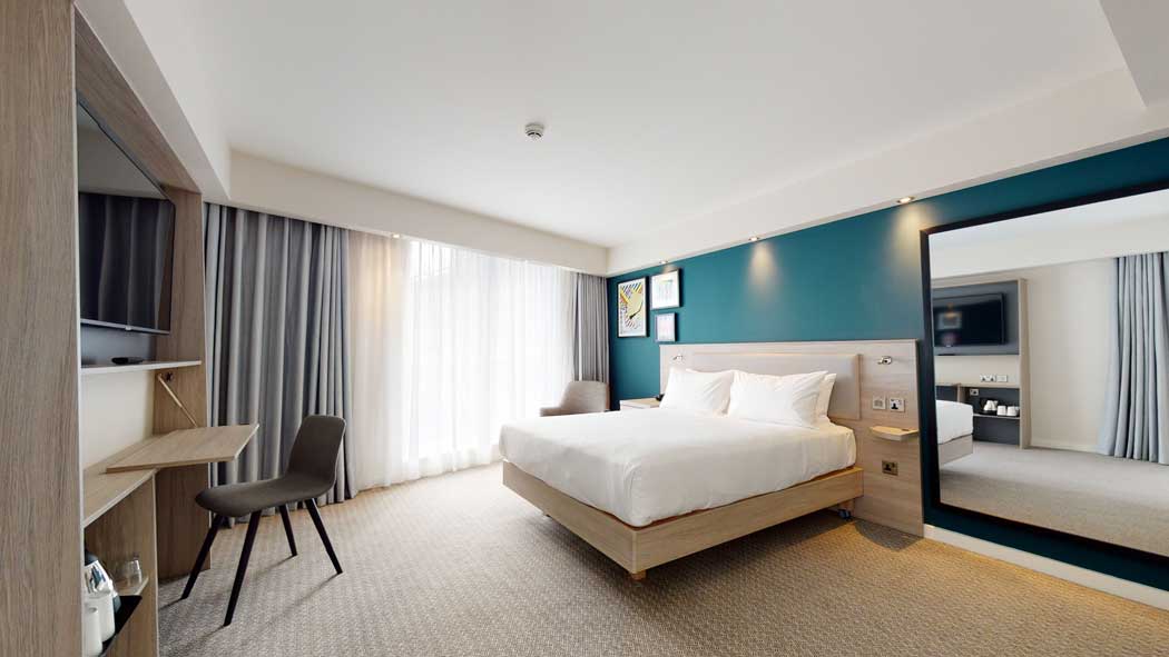A queen guest room with a city view. (Photo © 2020 Hilton)
