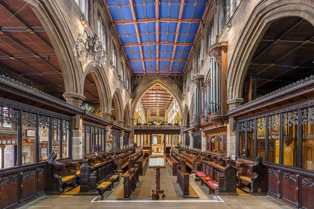 The choir features intricate wooden carving and a distinctive blue ceiling with red and golden detailing. (Photo by David Iliff. Licence: [CC BY-SA 3.0])