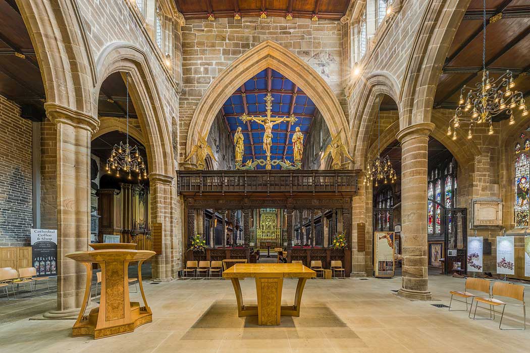 The 17th-century rood screen is one of the most prominent features of Wakefield Cathedral. It is topped by bright golden rood figures that were added in the mid-20th century. (Photo by David Iliff. Licence: [CC BY-SA 3.0])